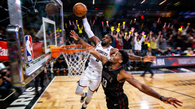 NBA球员在比赛中扣篮，展现激烈对抗
